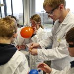 Schülerinnen und Schüler beim Experimentieren im Labor